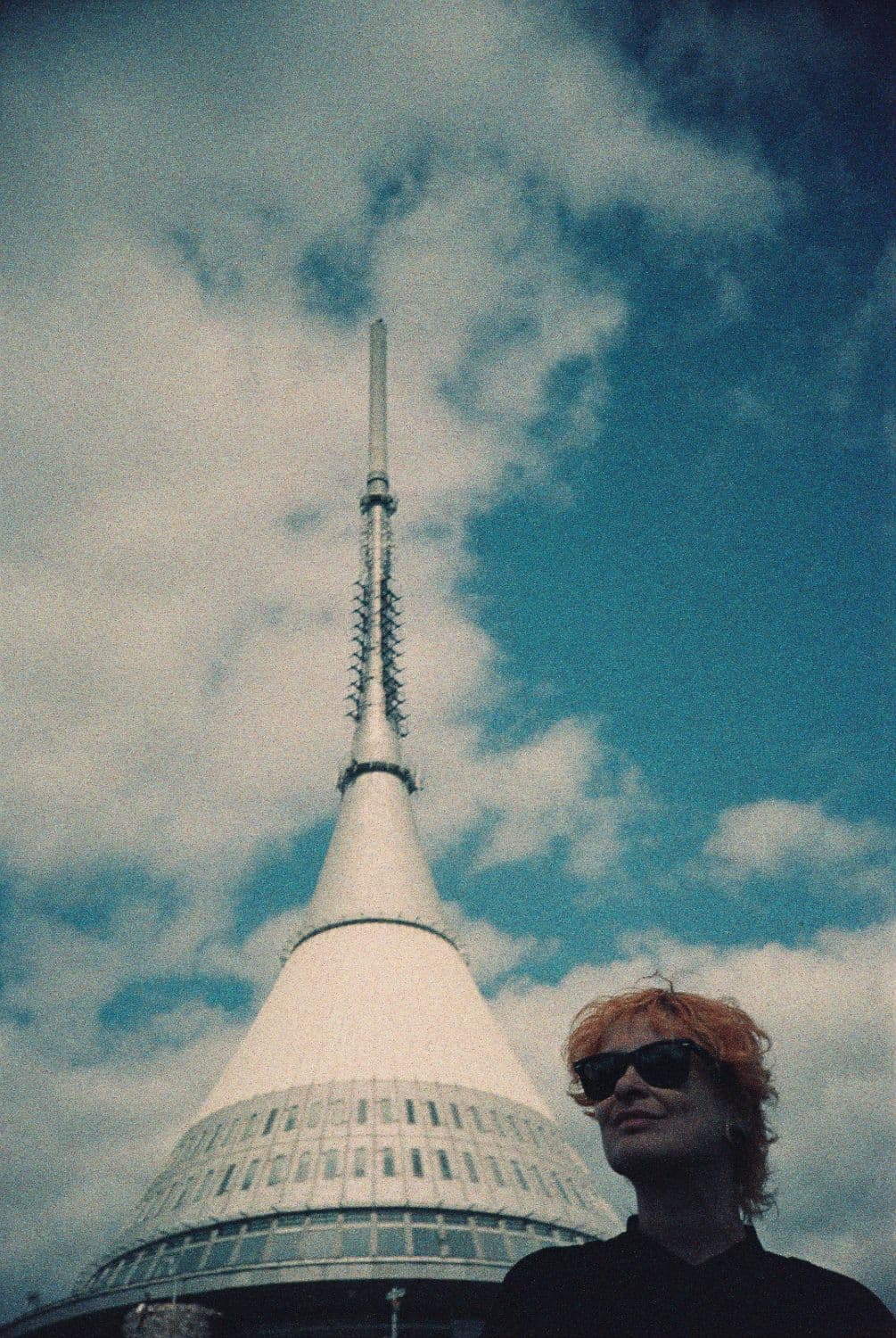 Elena Amabili in sunglasses, in front of the Ještěd tower